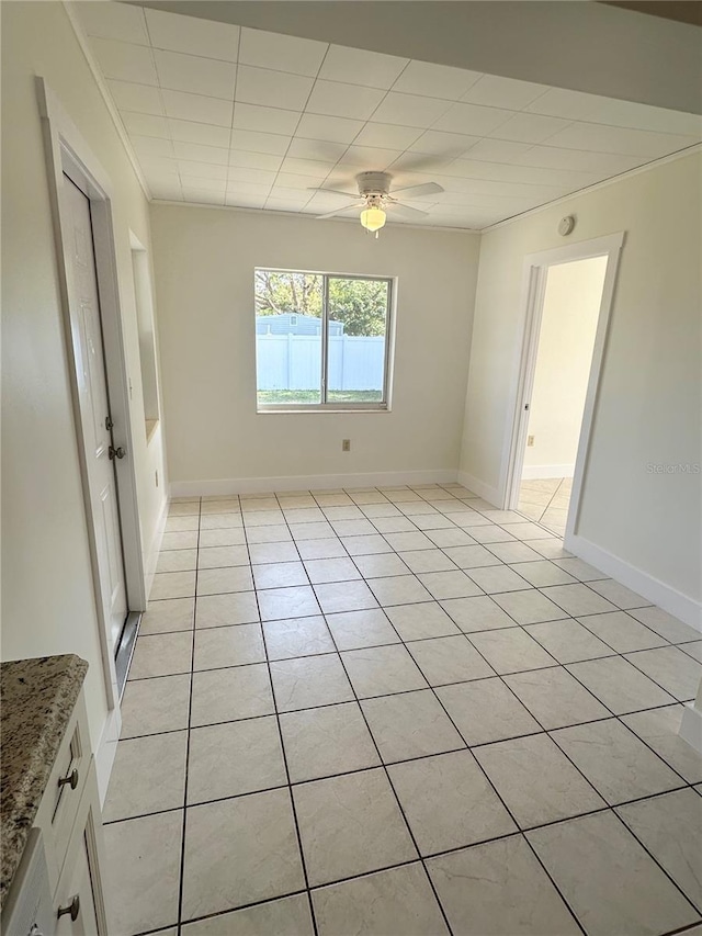 tiled spare room featuring ceiling fan