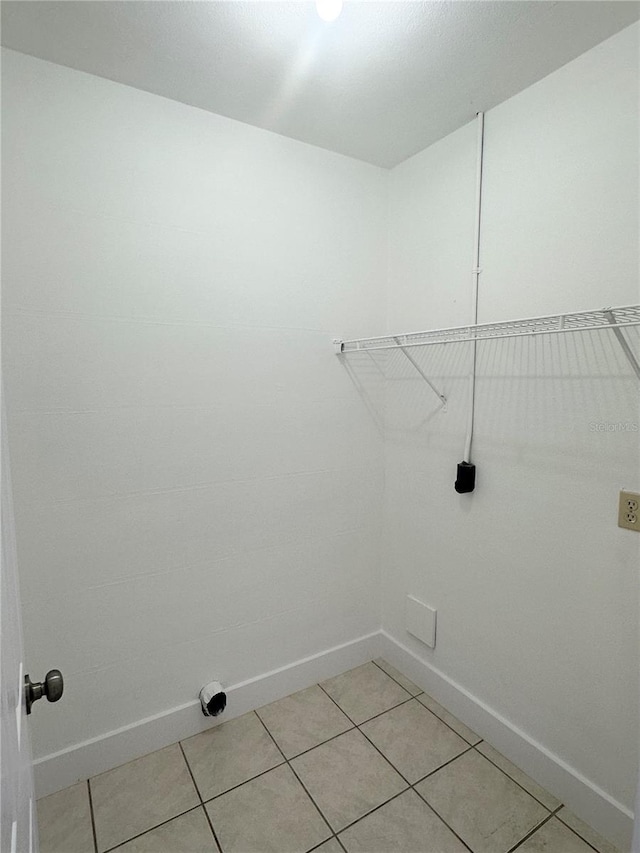 clothes washing area with hookup for an electric dryer and light tile patterned floors