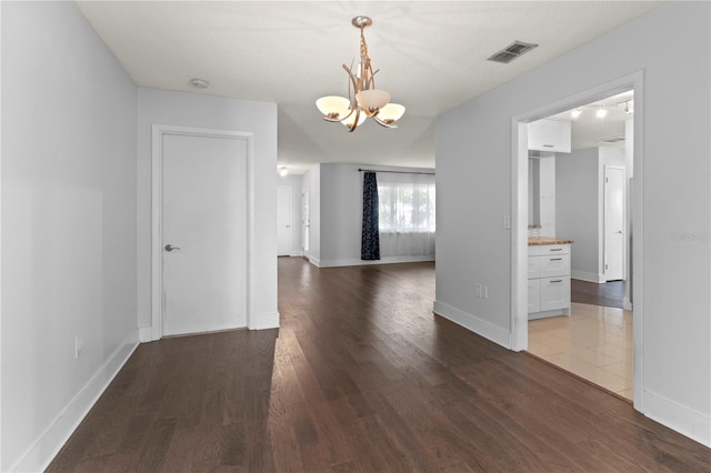 unfurnished dining area featuring dark hardwood / wood-style flooring and a chandelier