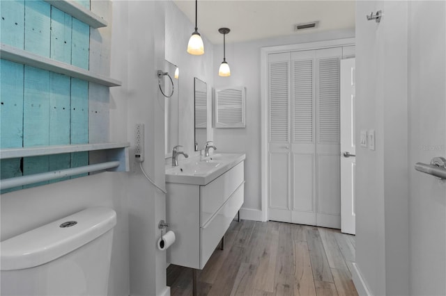 bathroom featuring vanity, hardwood / wood-style flooring, and toilet