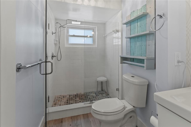 bathroom featuring a shower with door, vanity, hardwood / wood-style flooring, and toilet