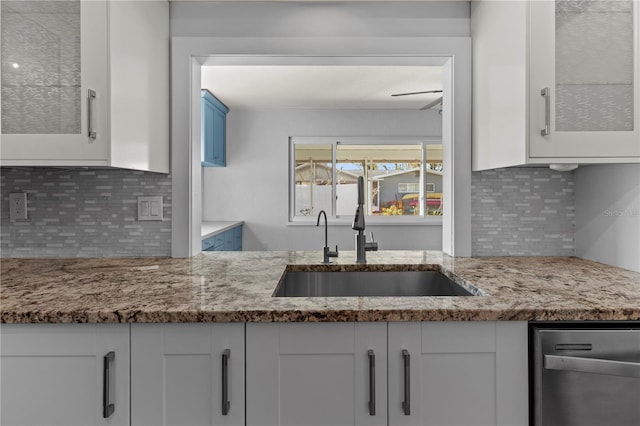 kitchen featuring tasteful backsplash, sink, and white cabinets