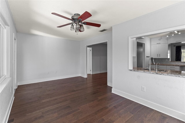 unfurnished room featuring sink, dark hardwood / wood-style floors, and ceiling fan