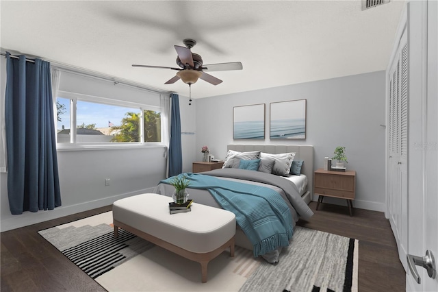 bedroom with wood finished floors, visible vents, baseboards, and ceiling fan