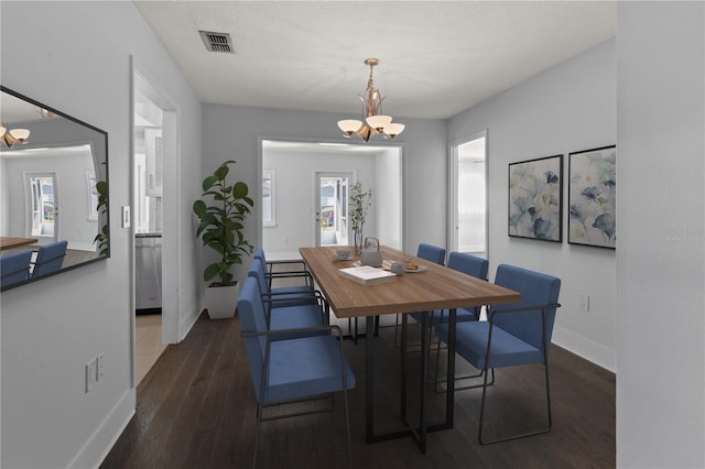 dining room featuring baseboards, visible vents, a notable chandelier, and dark wood-style floors