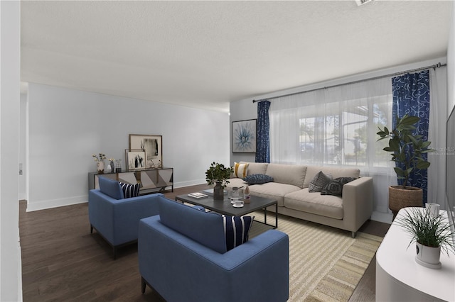 living area with wood finished floors, a textured ceiling, and baseboards