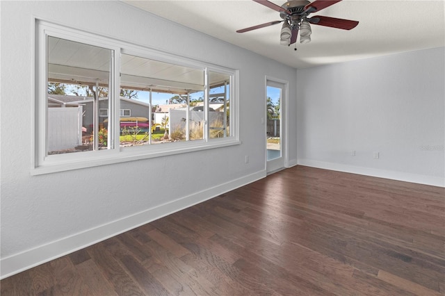 spare room featuring ceiling fan, baseboards, a healthy amount of sunlight, and wood finished floors