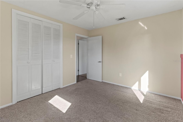 unfurnished bedroom featuring carpet flooring, visible vents, baseboards, a ceiling fan, and a closet