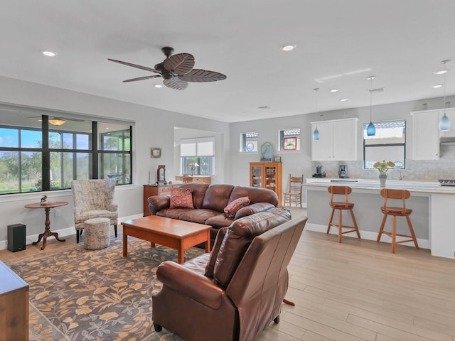 living room featuring ceiling fan and light hardwood / wood-style floors