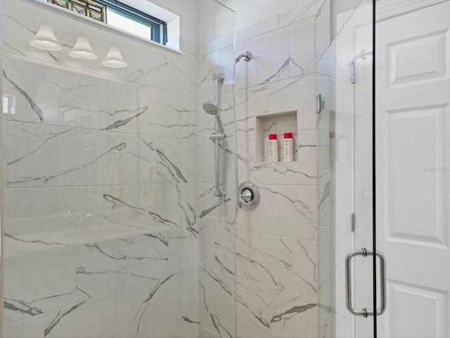 bathroom featuring a shower with shower door