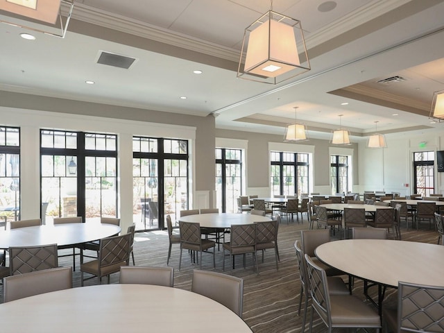 dining area with french doors, a raised ceiling, ornamental molding, and a healthy amount of sunlight