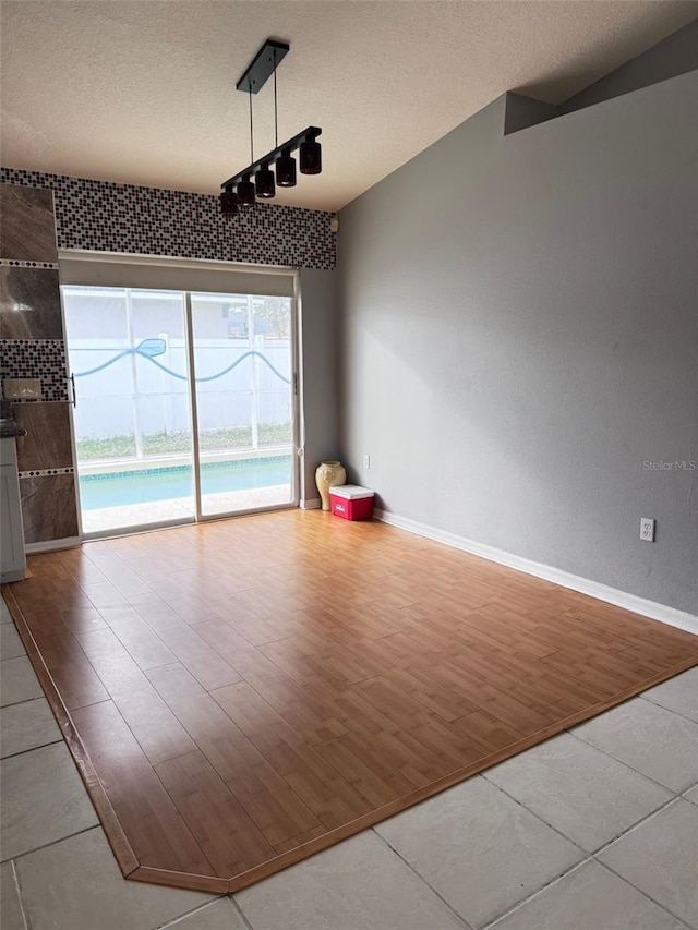 unfurnished dining area featuring light hardwood / wood-style floors and a textured ceiling