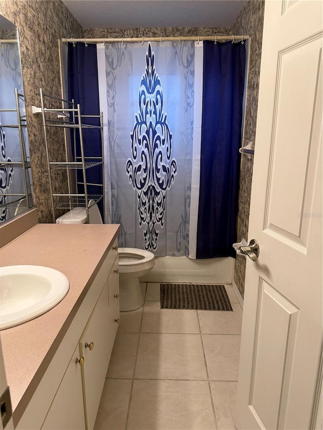 full bathroom featuring tile patterned flooring, vanity, toilet, and shower / bath combo with shower curtain