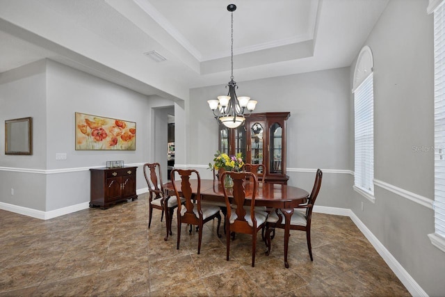 dining area featuring a chandelier, a tray ceiling, and a wealth of natural light