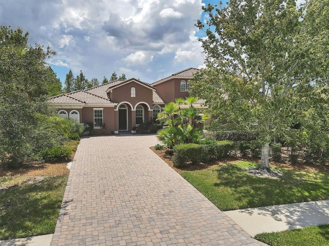 mediterranean / spanish house featuring a front yard