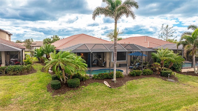 view of pool with a lawn, a patio area, and a lanai