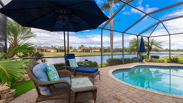 view of swimming pool featuring glass enclosure, a patio area, and a water view