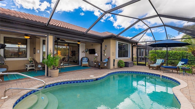 view of swimming pool with glass enclosure, ceiling fan, and a patio