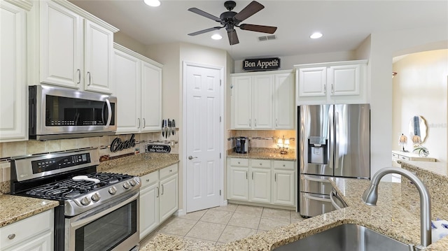 kitchen with decorative backsplash, stainless steel appliances, white cabinetry, and sink