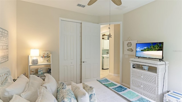 tiled bedroom featuring ceiling fan, washer / clothes dryer, and a closet