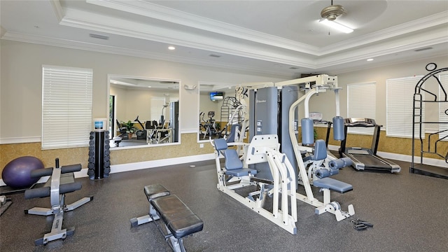 exercise room featuring a tray ceiling, ceiling fan, and crown molding