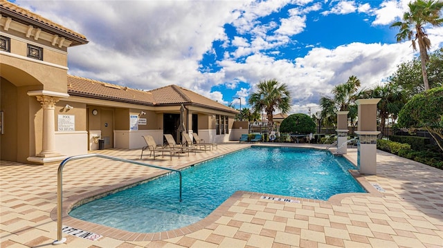 view of pool with pool water feature and a patio