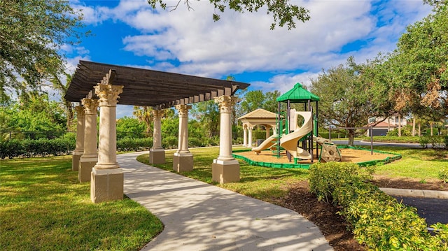 view of playground with a pergola and a lawn