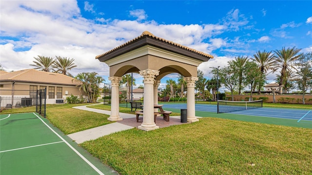 view of community featuring a yard and tennis court