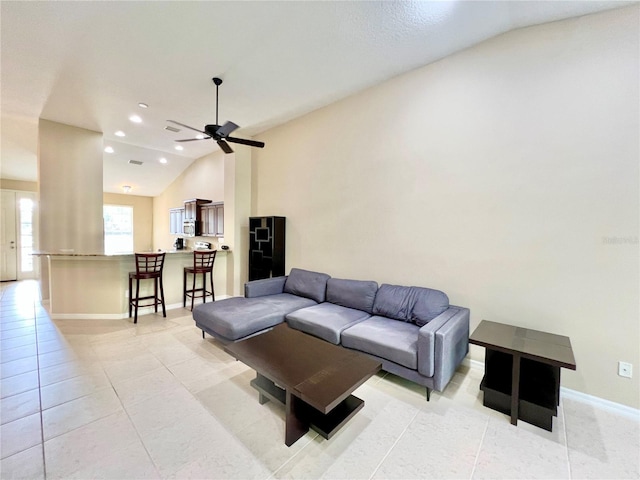 living room featuring light tile patterned floors, vaulted ceiling, and ceiling fan