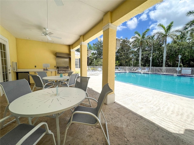 view of swimming pool featuring area for grilling, a grill, a patio, and ceiling fan