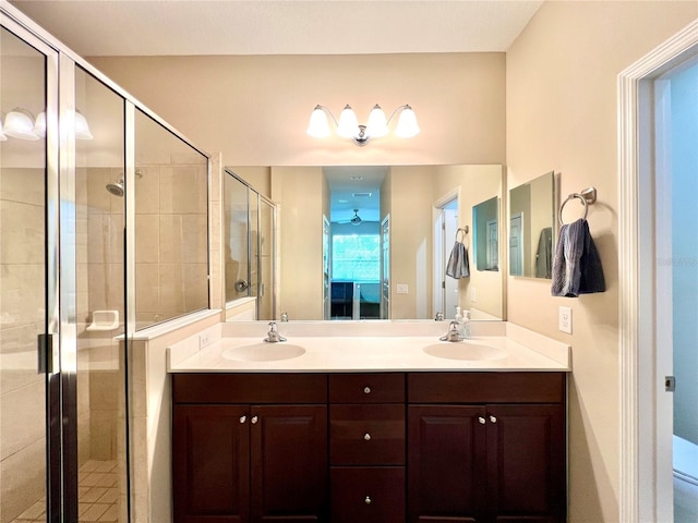 bathroom featuring a shower with door and vanity