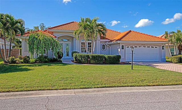 mediterranean / spanish house featuring french doors, a garage, and a front lawn