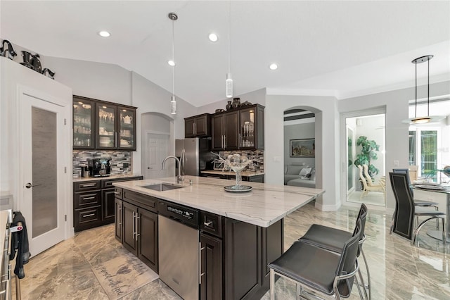 kitchen with pendant lighting, a large island with sink, sink, appliances with stainless steel finishes, and tasteful backsplash