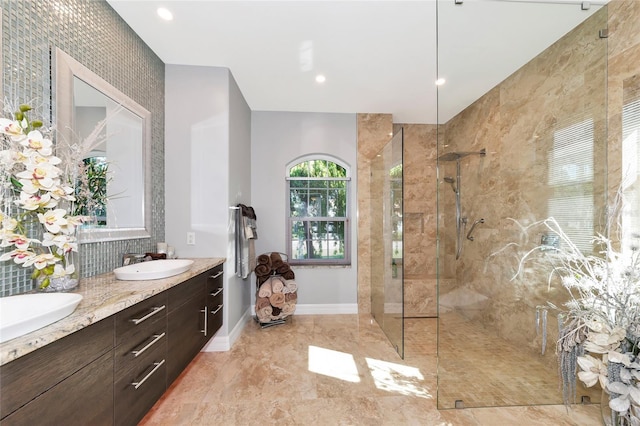 bathroom with a tile shower and vanity