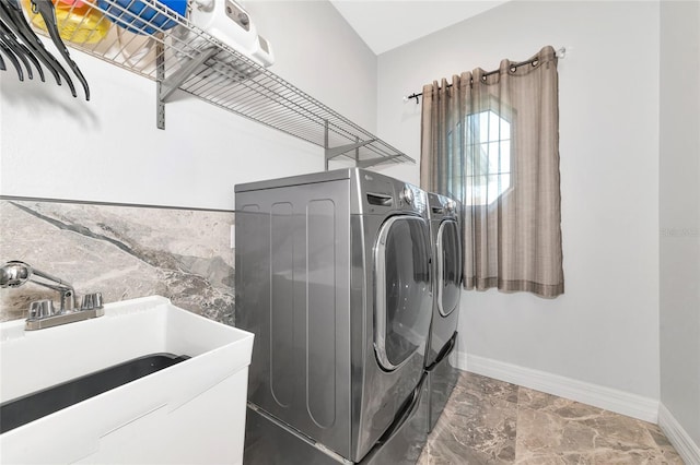 clothes washing area with independent washer and dryer and sink