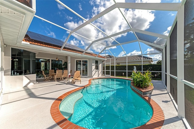 view of pool with a patio area and glass enclosure