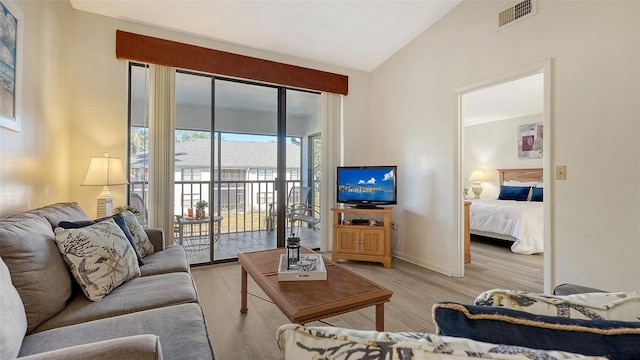 living room featuring light hardwood / wood-style flooring and lofted ceiling