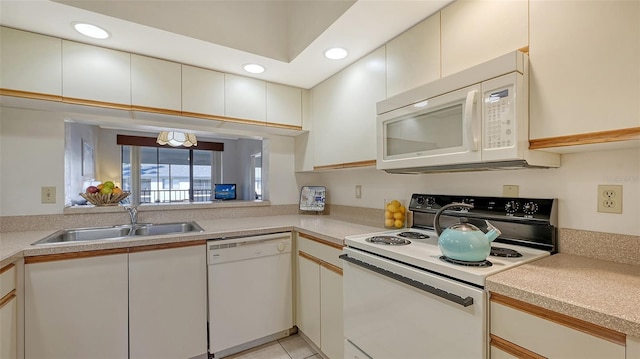 kitchen featuring white cabinets, light tile patterned flooring, white appliances, and sink