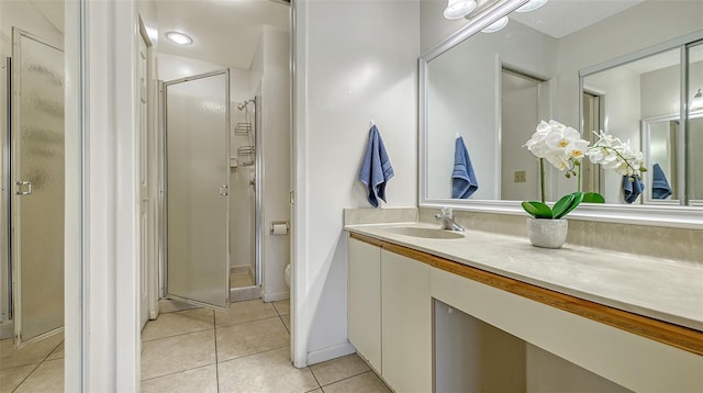 bathroom with tile patterned flooring, vanity, toilet, and a shower with door