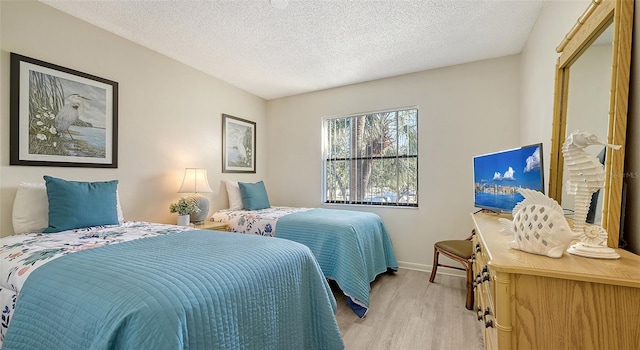 bedroom with light wood-type flooring and a textured ceiling