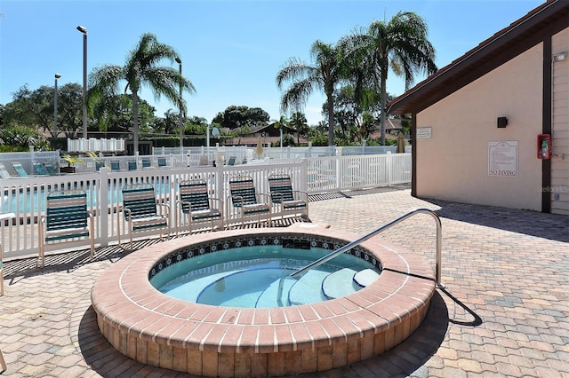 view of swimming pool with a hot tub and a patio area