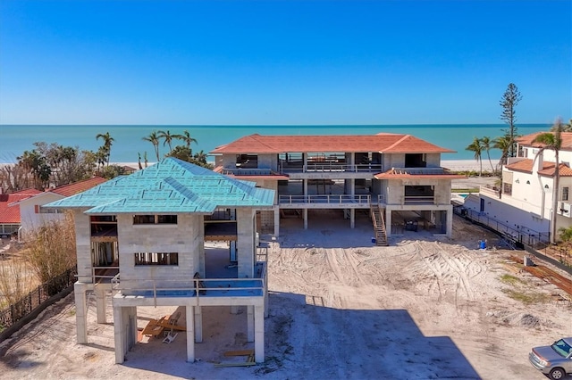 view of front of house with a water view and a balcony