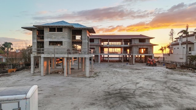 back of house at dusk with stone siding