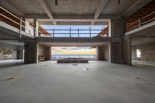 miscellaneous room with a towering ceiling and concrete flooring