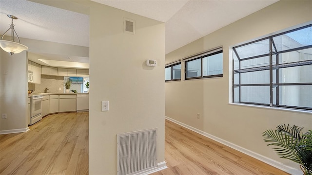 hall featuring light hardwood / wood-style floors, sink, and a textured ceiling