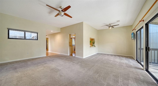 carpeted empty room featuring ceiling fan and a textured ceiling