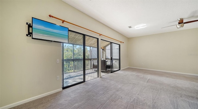 carpeted spare room with ceiling fan and a textured ceiling