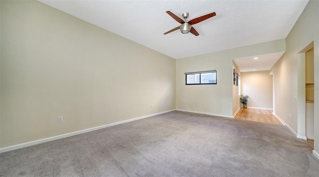 carpeted empty room featuring a textured ceiling and ceiling fan