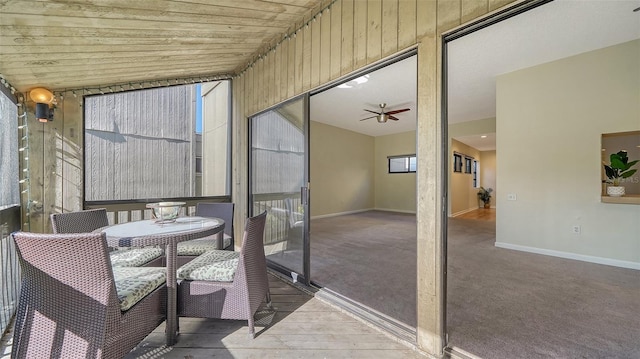 sunroom / solarium with vaulted ceiling, ceiling fan, and wood ceiling