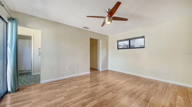 unfurnished room featuring ceiling fan, light hardwood / wood-style floors, and a textured ceiling